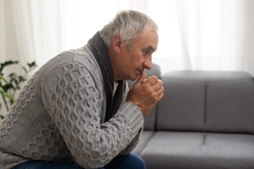 Elderly man grieves at home. Single people. Man upset headache